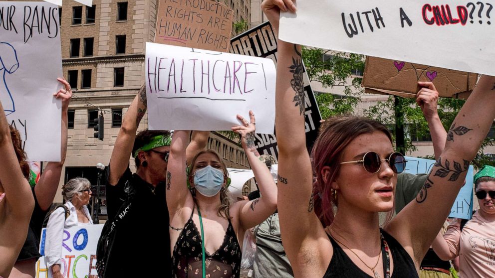 PHOTO: Protesters hold placards expressing their opinion at a pro abortion rights rally in Dayton, Ohio, May 14, 2022.