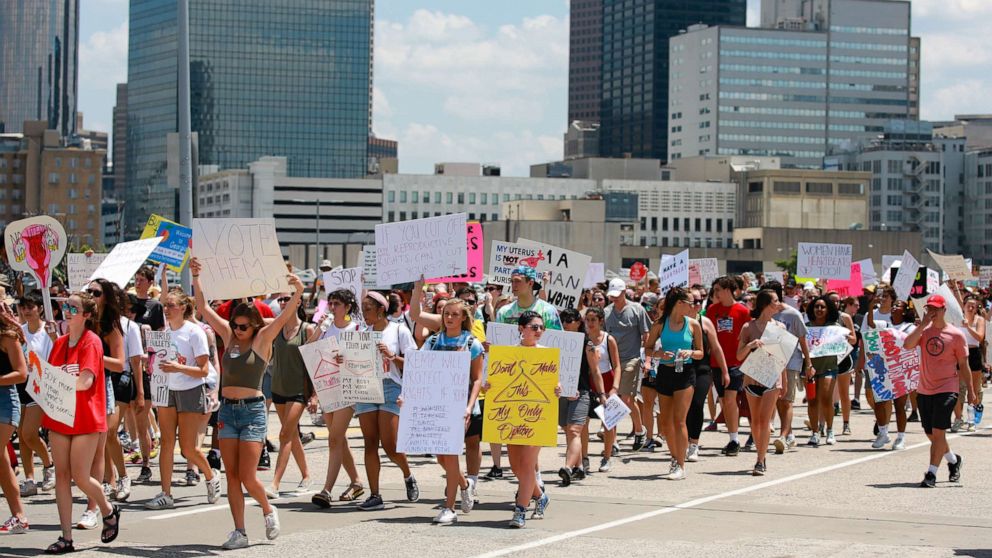 PHOTO: Demonstrators hold signs while marching during a protest against Georgia's "heartbeat" abortion bill in Atlanta, May 25, 2019.