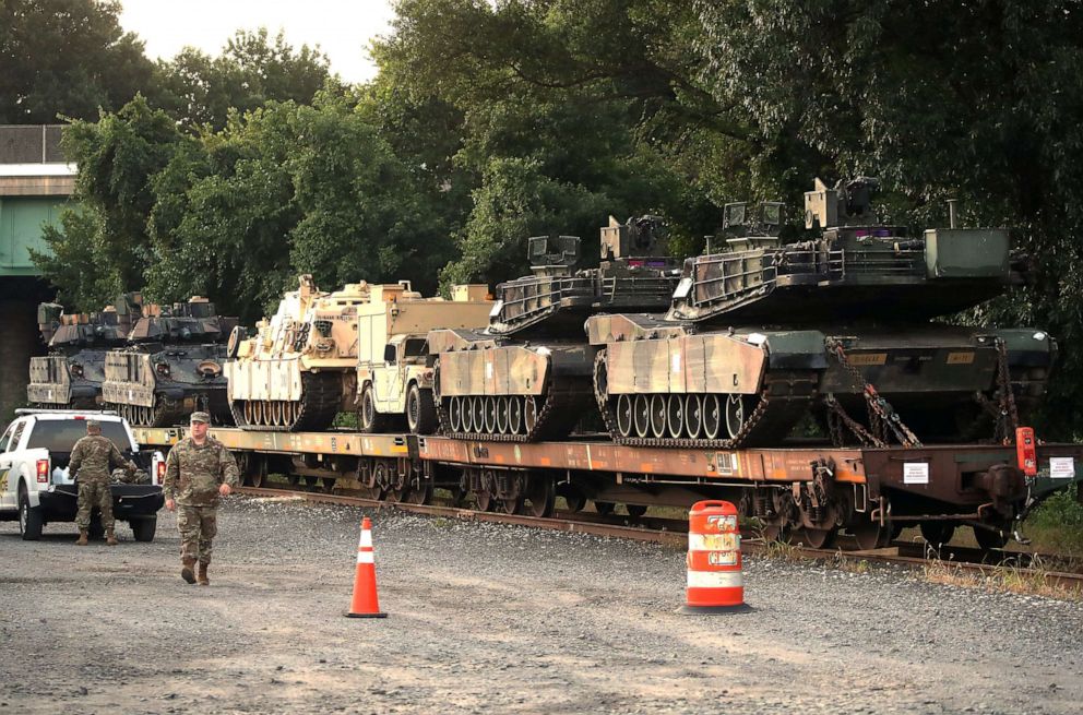 PHOTO: Two M1A1 Abrams tanks and other military vehicles sit on guarded rail cars at a rail yard on July 2, 2019, in Washington, D.C.