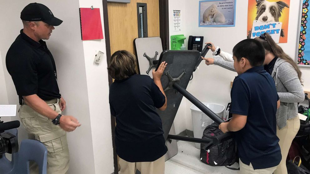 PHOTO: Joe Deedon, owner of Tac One Consulting, instructs sixth graders at Pinnacle Middle School in Denver how to barricade a classroom to stop an active shooter.