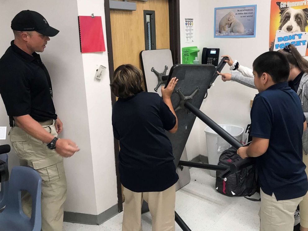 PHOTO: Joe Deedon, owner of Tac One Consulting, instructs sixth graders at Pinnacle Middle School in Denver how to barricade a classroom to stop an active shooter.