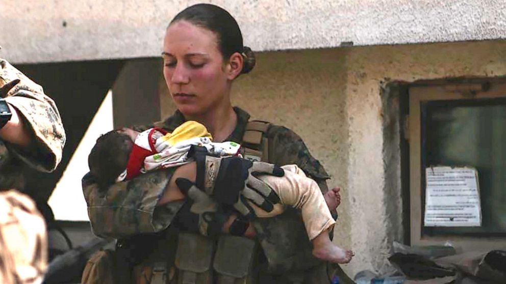 PHOTO: This undated photo provided by U.S. Department of Defense twitter page posted Aug. 20, 2021 shows Sgt. Nicole Gee holding a baby at Hamid Karzai International Airport in Kabul, Afghanistan.  