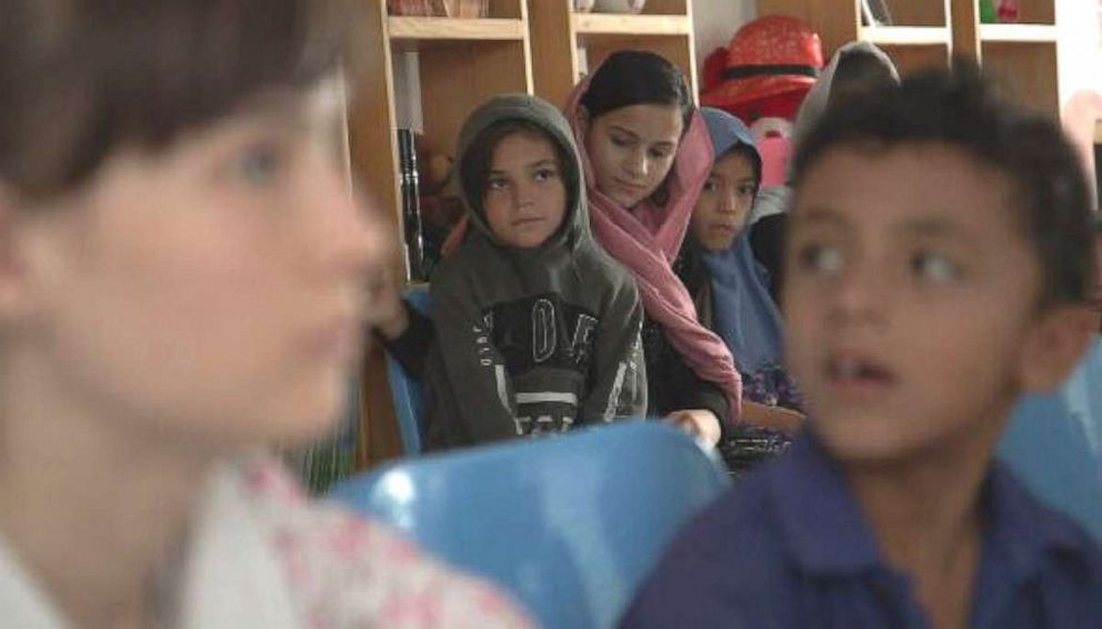 PHOTO: A teacher gives lessons to Zarlasht and other children in Salam Cafe.