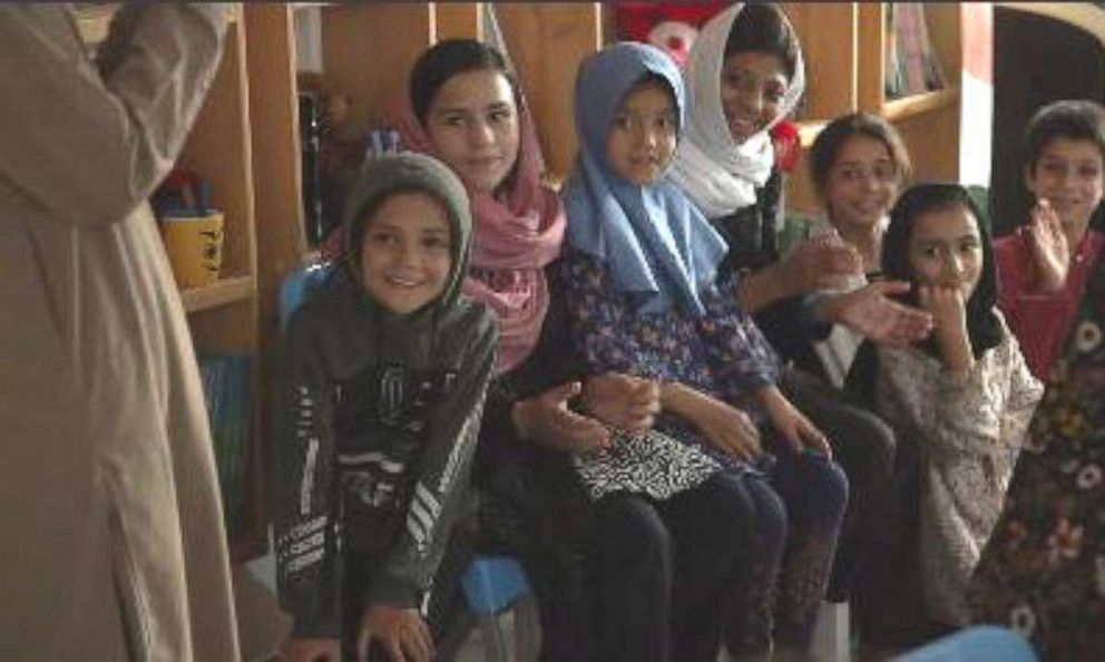 PHOTO: A teacher gives lessons to Zarlasht and other children in Salam Cafe. 