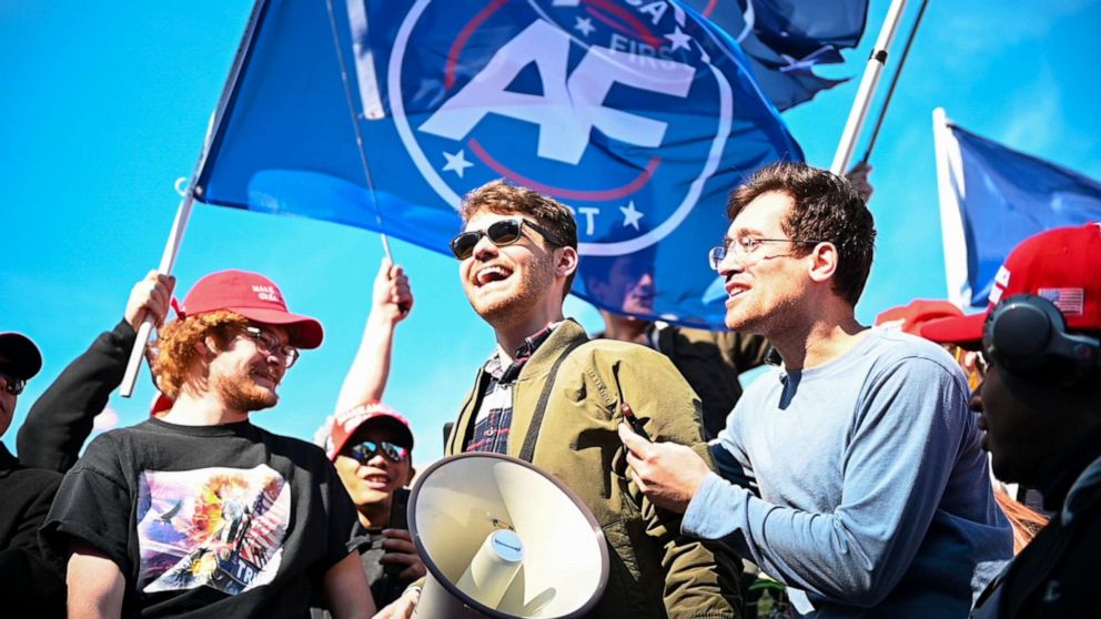 PHOTO: In this Nov. 14, 2020 file photo Nick Fuentes speaks to his followers, the Groypers, while flying a flag reading "America First", in Washington D.C. 