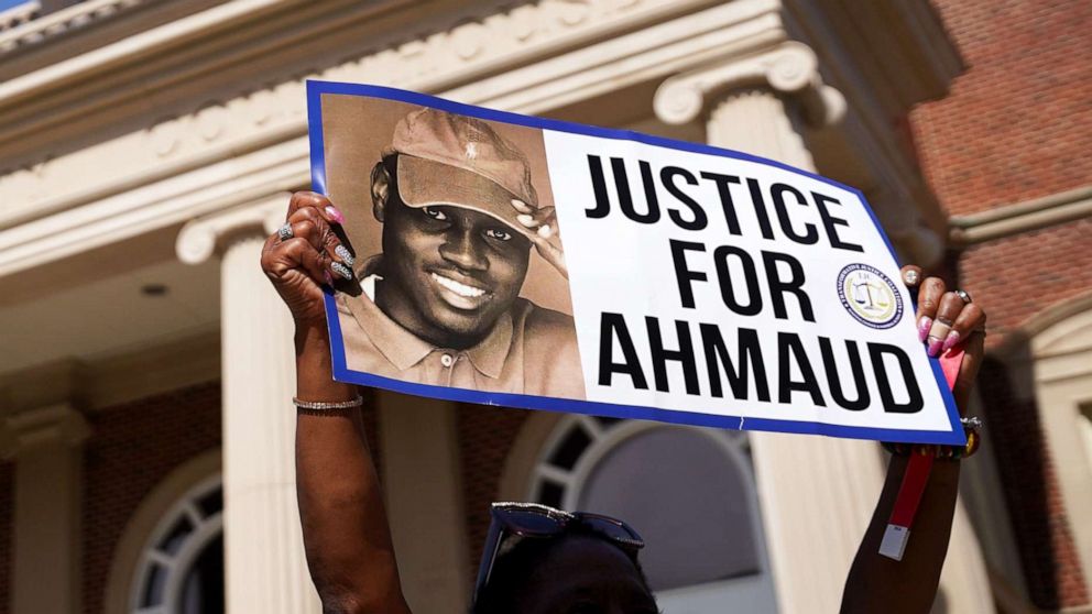 PHOTO: A demonstrator holds a sign at the Glynn County Courthouse as jury selection begins in the trial of the shooting death of Ahmaud Arbery in Brunswick, Ga., Oct. 18, 2021.