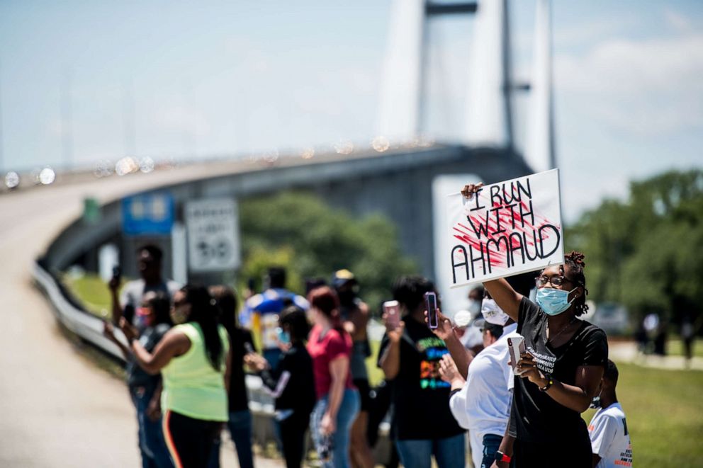 PHOTO: Demonstrators watch a parade of passing motorcyclists riding in honor of Ahmaud Arbery at Sidney Lanier Park on May 9, 2020 in Brunswick, Ga. Arbery was shot and killed while jogging in the nearby Satilla Shores neighborhood on Feb. 23. 