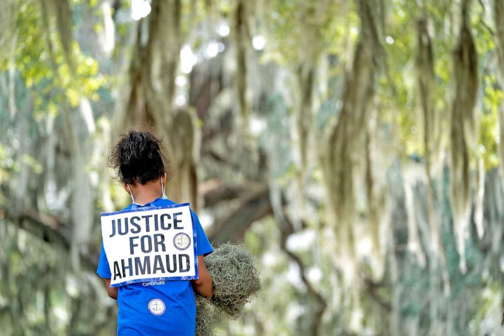 PHOTO: Nevaeh DelRio carries Spanish moss  at the Glynn County Courthouse as jury selection begins in the trial of the shooting death of Ahmaud Arbery on Oct. 18, 2021 in Brunswick, Ga. 