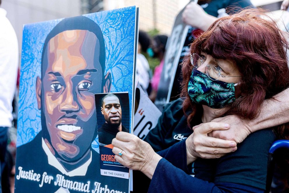 PHOTO: A woman holds portraits of Ahmaud Arbery and George Floyd during an event in remembrance of George Floyd in Minneapolis, on May 23, 2021.