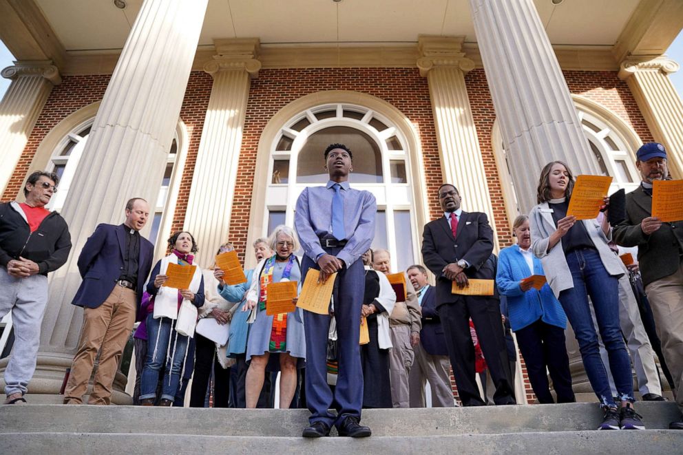 PHOTO: Religious leaders sing at the Glynn County Courthouse as jury selection begins in the trial of the shooting death of Ahmaud Arbery on Oct. 18, 2021 in Brunswick, Ga. 