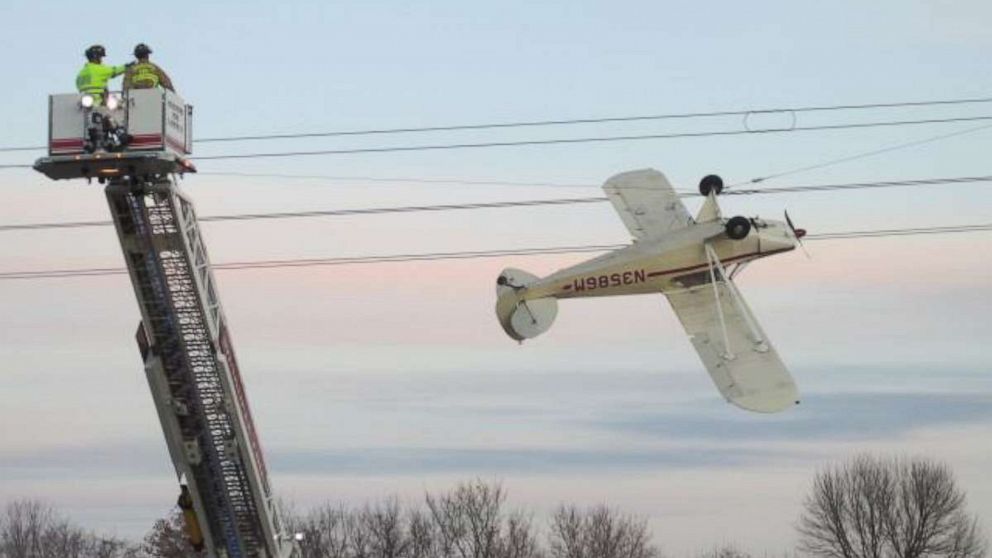 Pilot rescued after small plane becomes entangled upside down in po ...