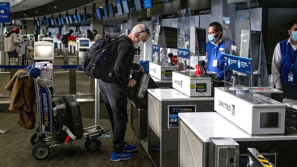 PHOTO: A traveler wearing a protective mask checks in at the United Airlines check-in counter at San Francisco International Airport in San Francisco, Dec. 21, 2020. 