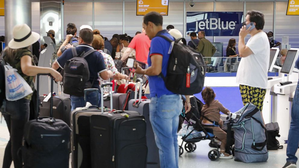 PHOTO: In this May 21, 2022, file photo, travelers wait in line at the JetBlue counter at Fort Lauderdale-Hollywood International Airport in Fort Lauderdale, Fla.