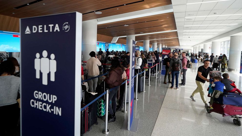 PHOTO: Passengers wait in line at the Delta Air Lines terminal at Los Angeles International Airport, December 25, 2022.