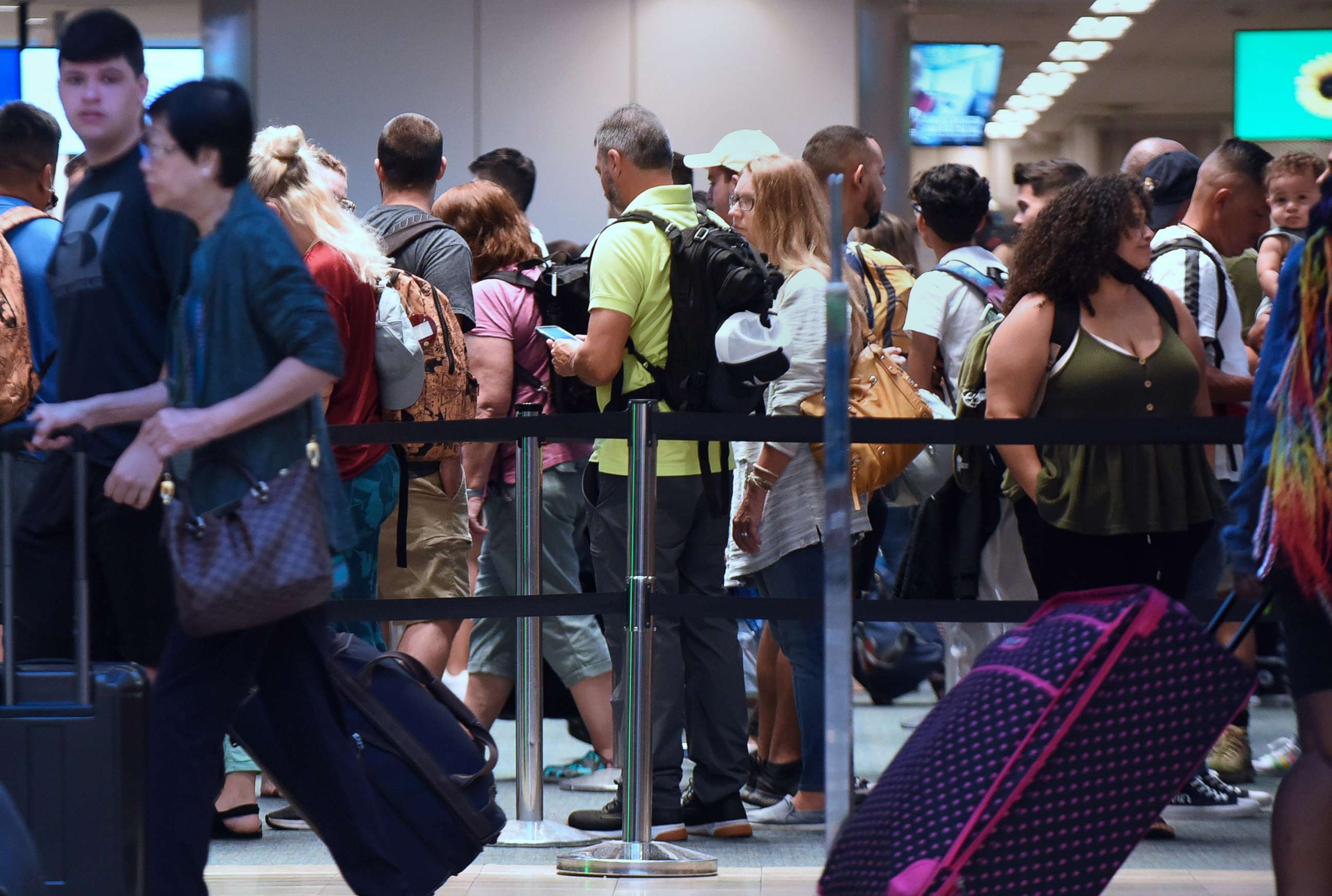 PHOTO: Travelers make their way through a TSA screening line at Orlando International Airport, July 1, 2022. 