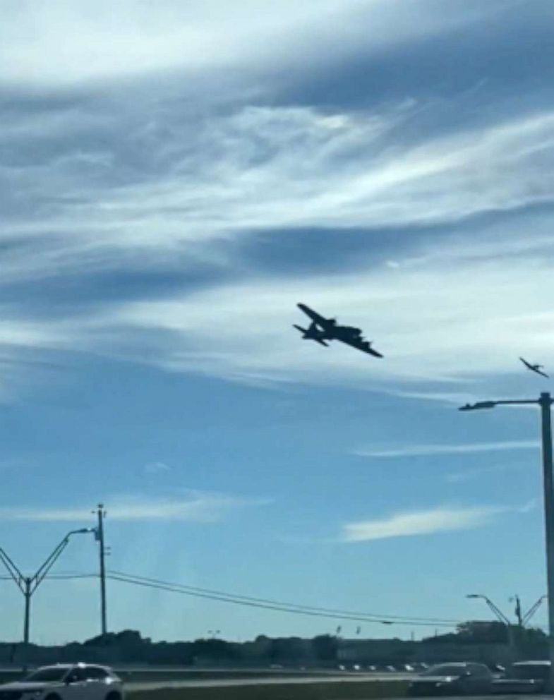 PHOTO: In this screen grab from a video, a plane flies over a highway before a crash at a World War II airshow at Dallas Executive Airport, Nov. 12, 2022.