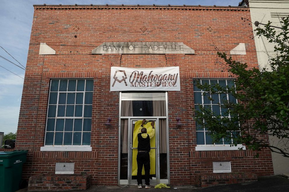 PHOTO: Norman Brooks covers the door of the Mahogany Masterpiece dance studio, the scene of last night's deadly shooting, on April 16, 2023 in Dadeville, Ala.