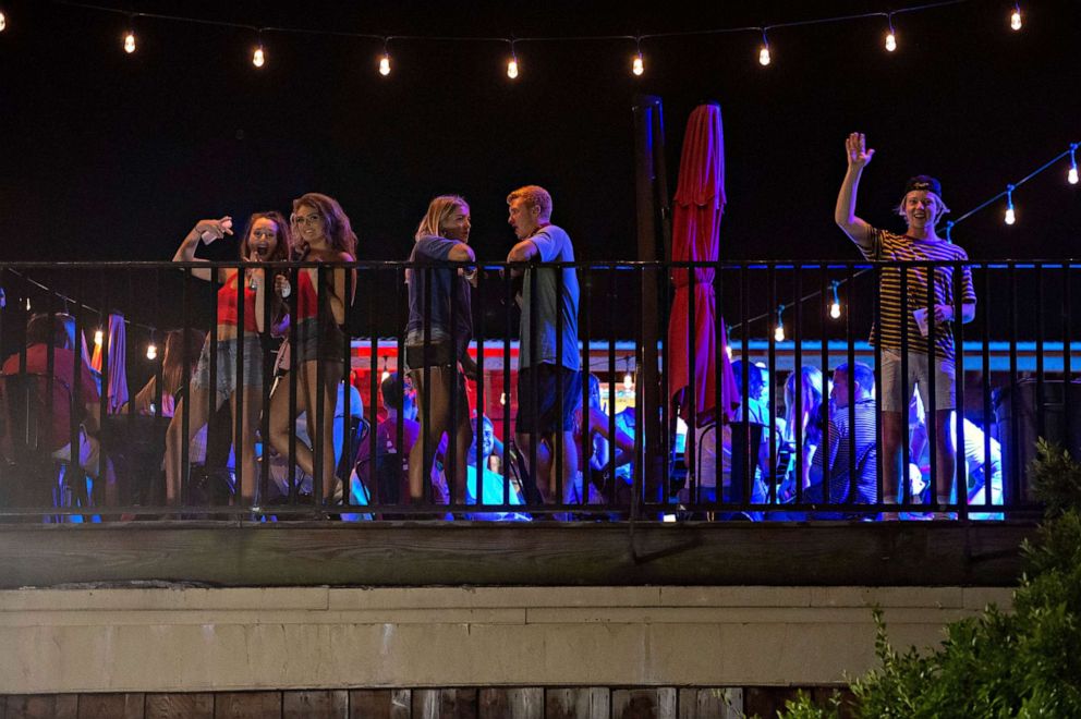 PHOTO: Patrons stand on the Bear Trap's rooftop bar on The Strip, the University of Alabama's bar scene, Aug. 15, 2020, in Tuscaloosa, Ala.