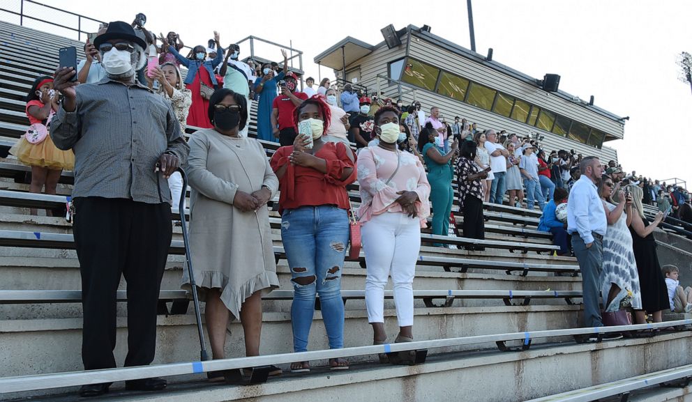 PHOTO: Families wear masks and practice social distancing during Central High School's first of five live graduation ceremonies at Garrett-Harrison Stadium in in Phenix City, Ala.
