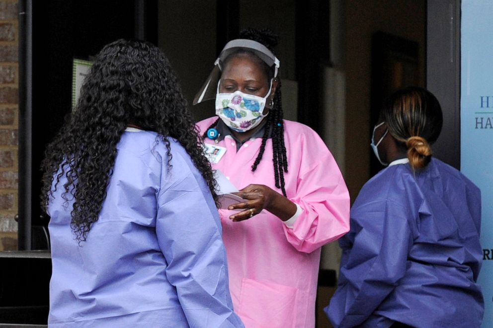 PHOTO: Health care workers talk outside a Lowndes County coronavirus testing site in Hayneville, Ala., May 27, 2020.