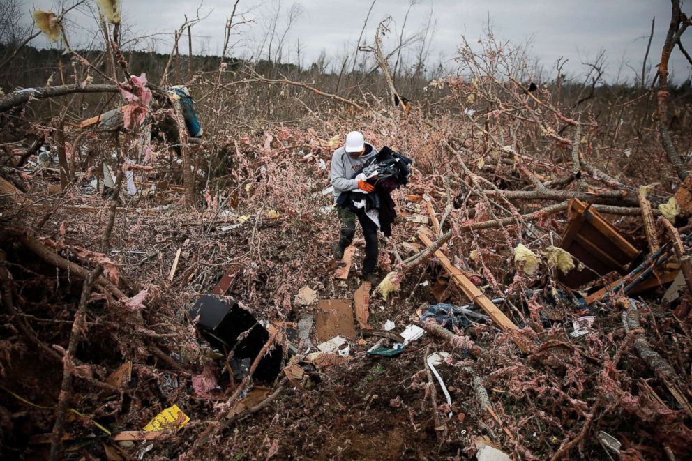 PHOTO: Dax Leandro salvages clothing from the wreckage of his friend's home after two back-to-back tornadoes touched down, in Beauregard, Ala., March 4, 2019.