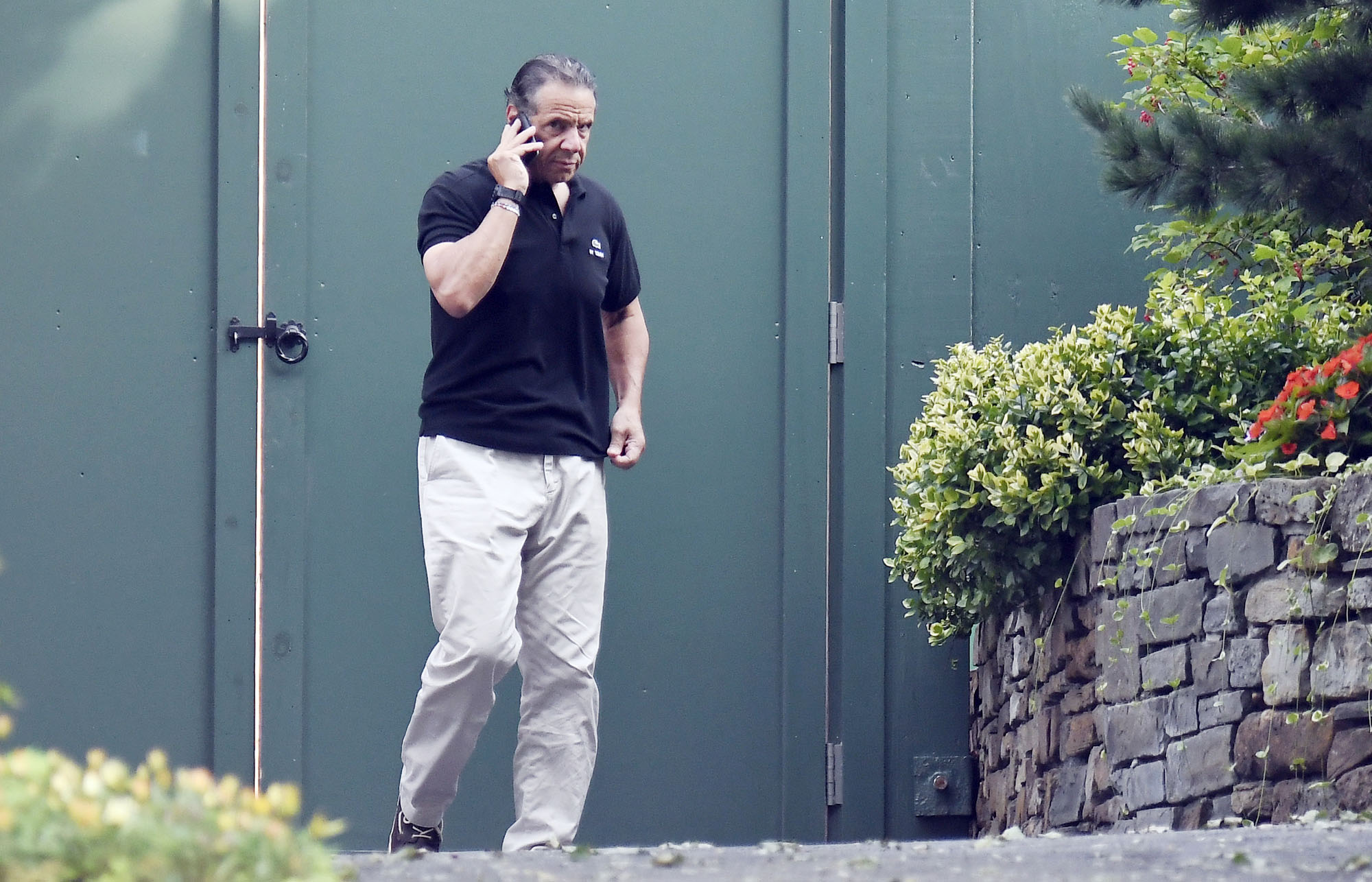 PHOTO: Gov. Andrew Cuomo talks on the phone while walking at the New York state Executive Mansion in Albany N.Y., Aug. 7, 2021.