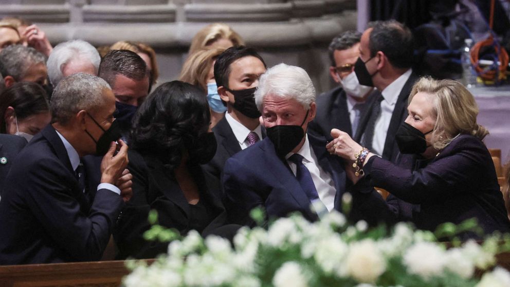 PHOTO:Former President Obama and Michelle Obama watch as Hillary Clinton pins a Ukrainian flag pin on the jacket of former President Bill Clinton as they gather for the funeral of former Secretary of State Madeleine Albright in Washington, April 27, 2022.