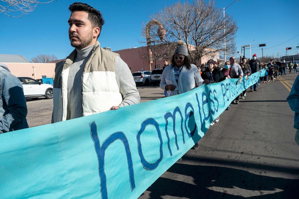 PHOTO: People carry a banner during a silent march to Wells Park to honor the memories of Homeless who died in 2022, in Albuquerque, on Dec. 21, 2022.