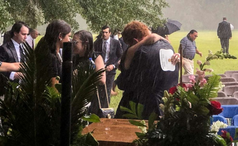 PHOTO: In this June 11, 2021, file photo, Buster Murdaugh, center, receives a hug in the rain during the funeral service for his brother, Paul, and mother, Maggie, in Hampton, S.C.