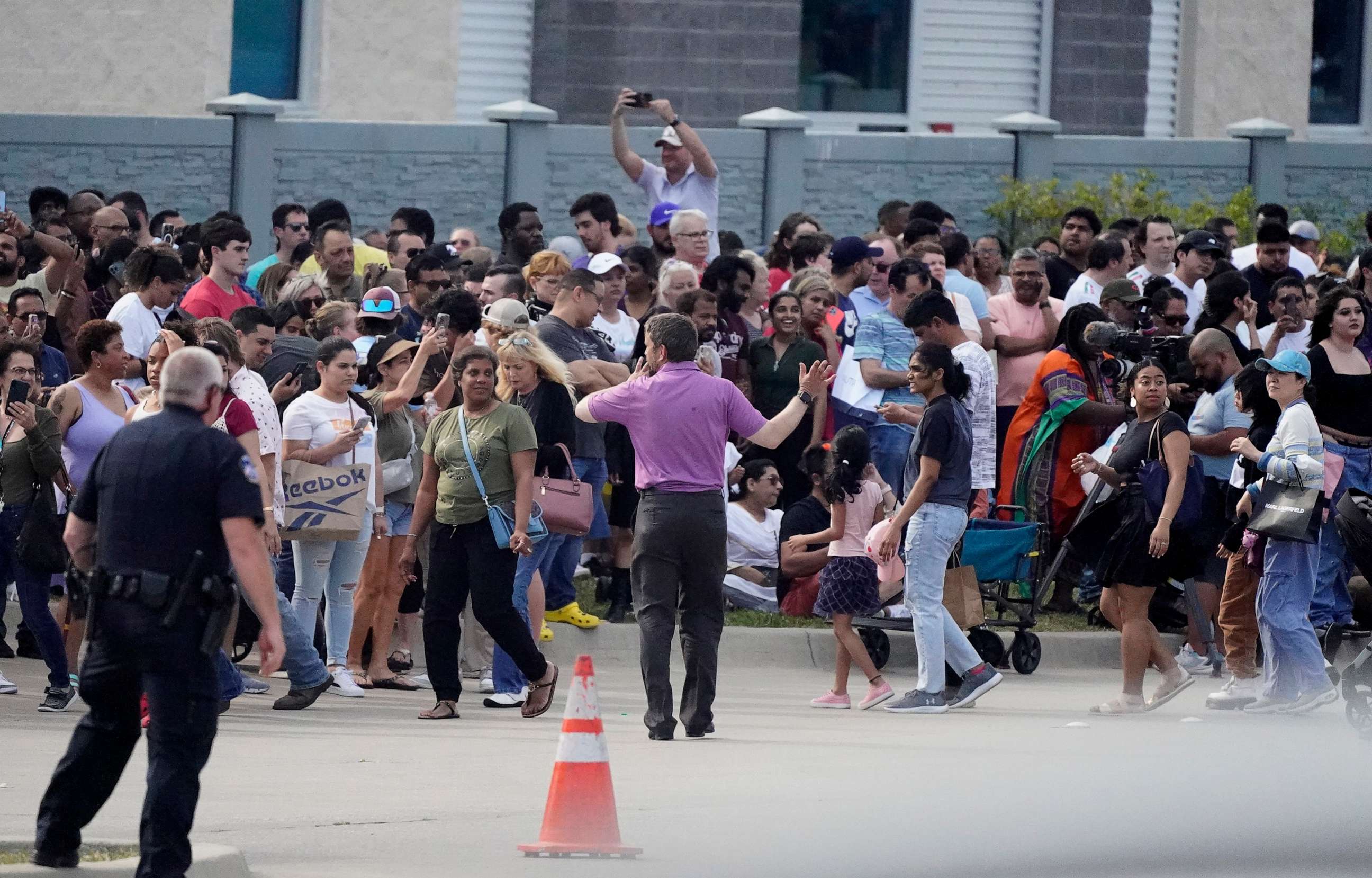 PHOTO: People gather across the street from a shopping center after a shooting, May 6, 2023, in Allen, Texas.