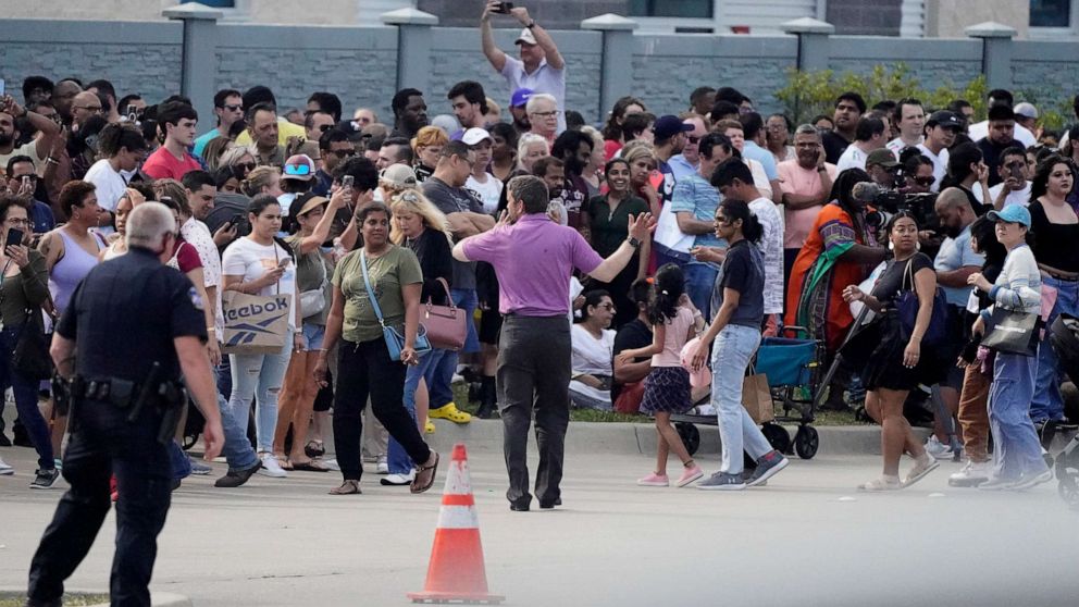 PHOTO: People gather across the street from a shopping center after a shooting, May 6, 2023, in Allen, Texas.
