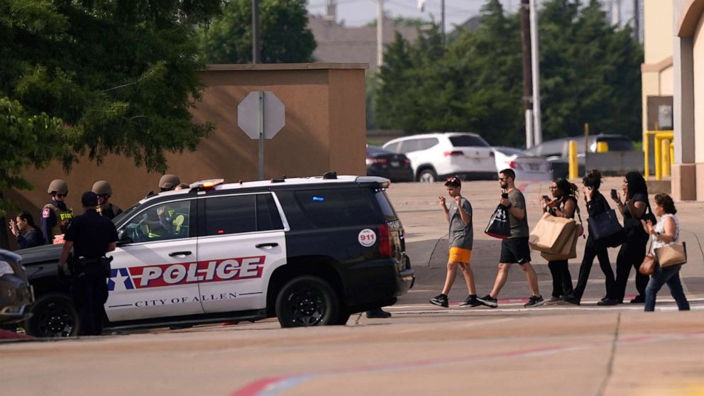 PHOTO: People raise their hands as they leave a shopping center after a shooting, May 6, 2023, in Allen, Texas.