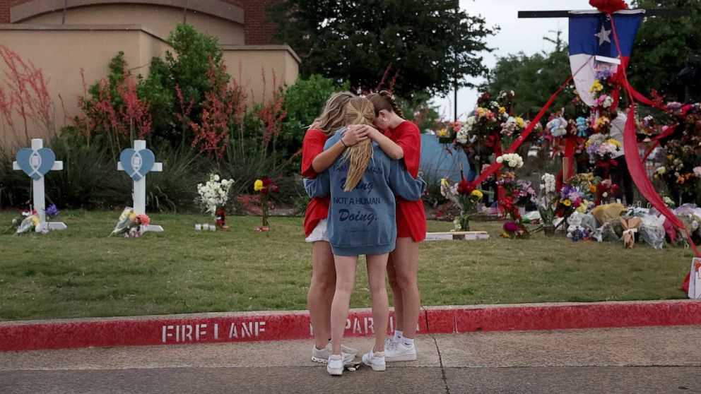 PHOTO: People pray near a makeshift memorial setup near an entrance to the Allen Premium Outlets mall following the mass shooting, May 8, 2023 in Allen, Texas.