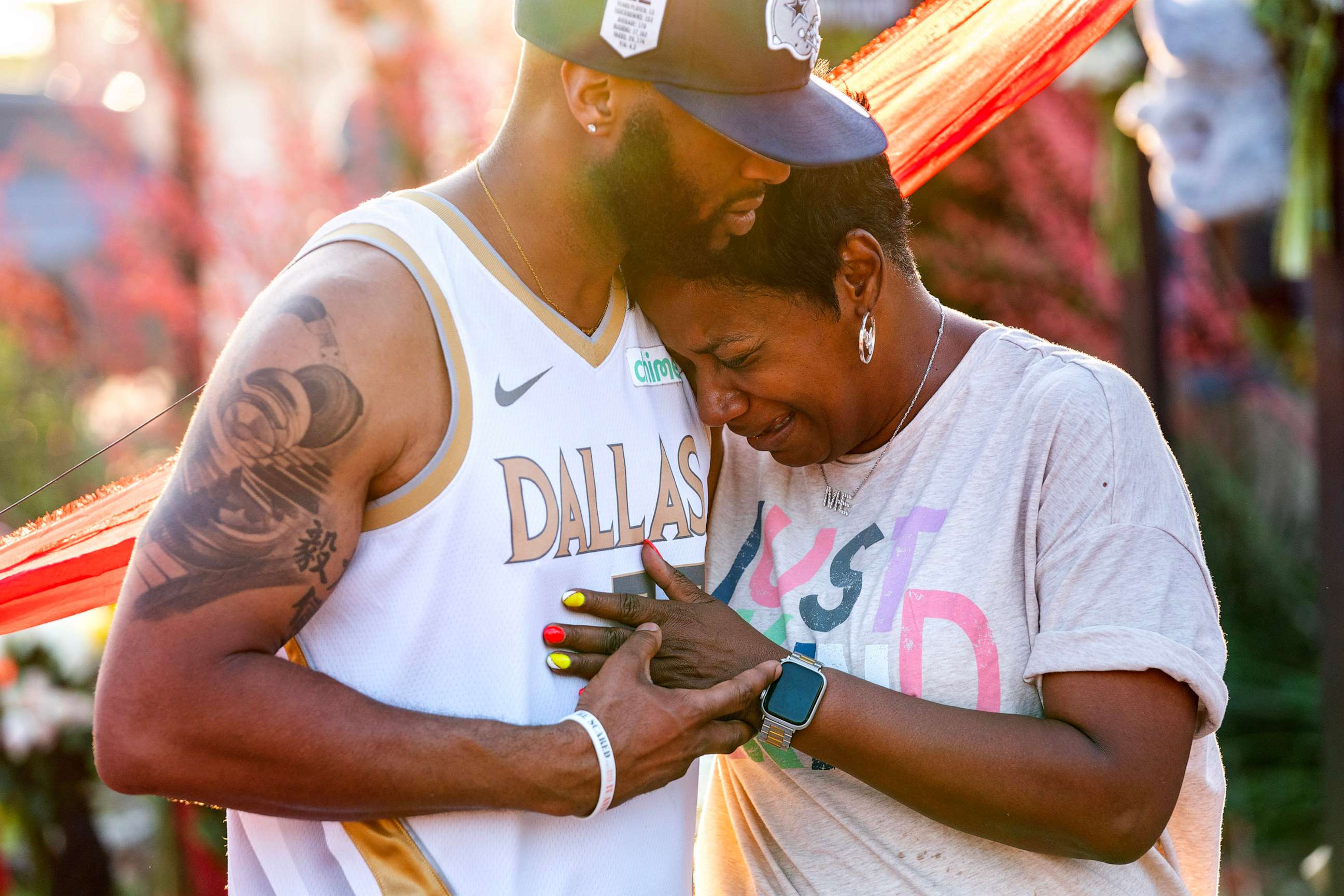 PHOTO: Robert Jackson consoles Cheryl Jackson at a makeshift memorial outside the Allen Premium Outlets, May 8, 2023, in Allen, Texas.