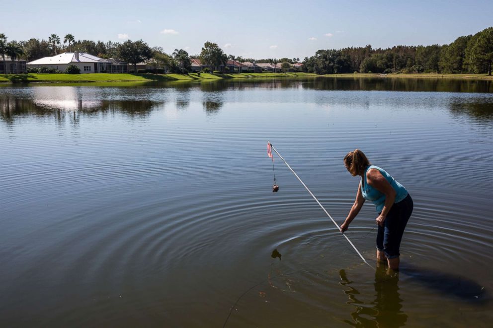 PHOTO: Julie Harter sets bait on a hook to trap an alligator. 