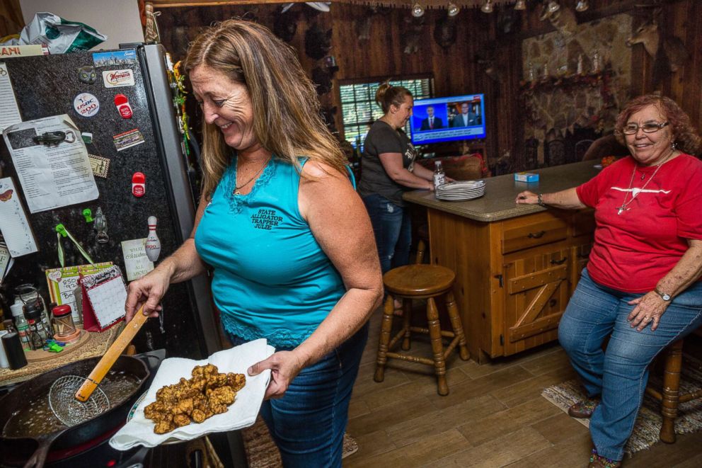 PHOTO: Cooking fried alligator meat, Julie Harter prepares dinner with her family, including daughter Monica and mother Ellen, right, at her home in Lakeland, Fla.