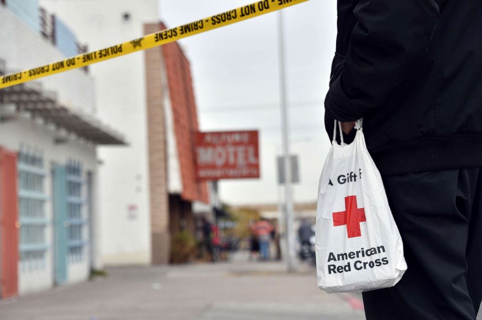 PHOTO: A displaced resident carries a bag from the Red Cross after a fire at a three-story apartment complex, Dec. 21, 2019 in Las Vegas. 