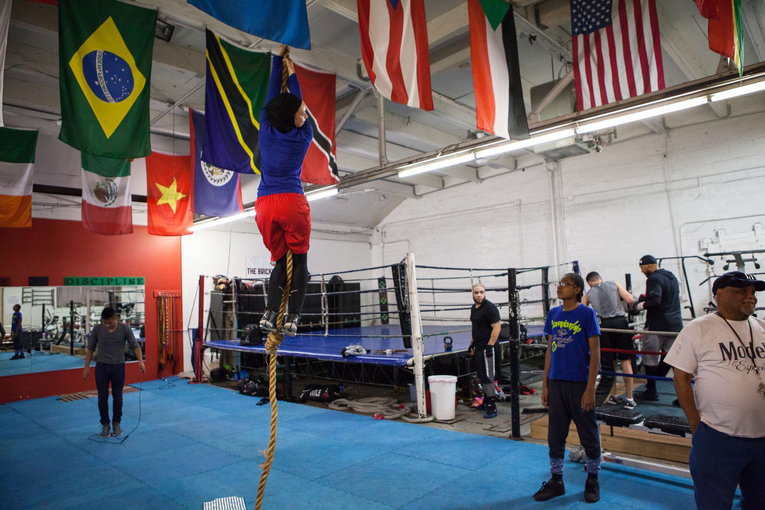 PHOTO: Amaiya Zafar attempts to climb the rope and touch the ceiling at Circle of Discipline boxing gym in Minneapolis.
