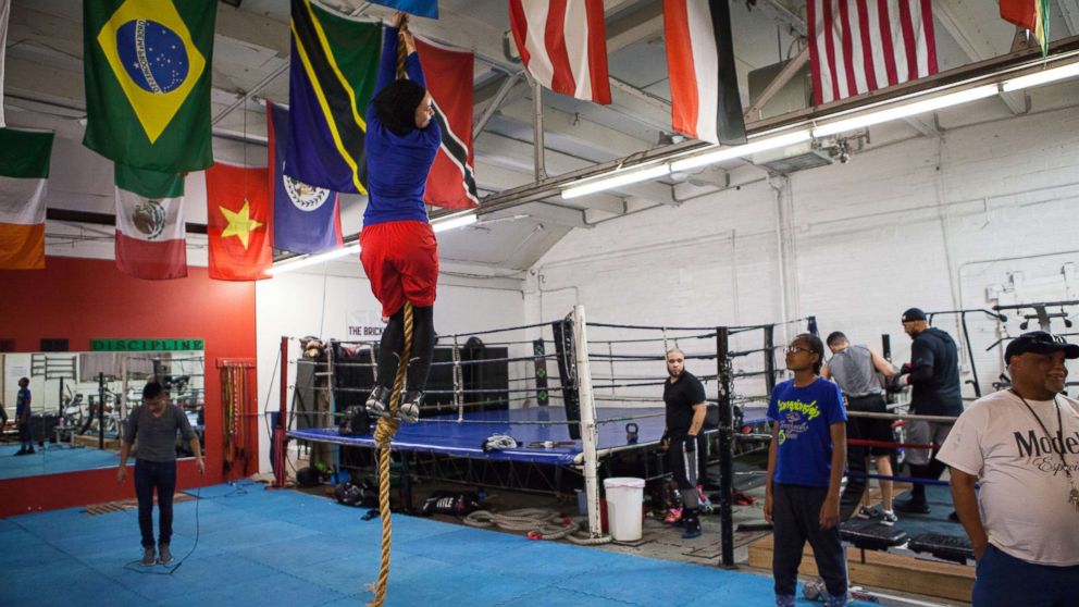 PHOTO: Amaiya Zafar attempts to climb the rope and touch the ceiling at Circle of Discipline boxing gym in Minneapolis.