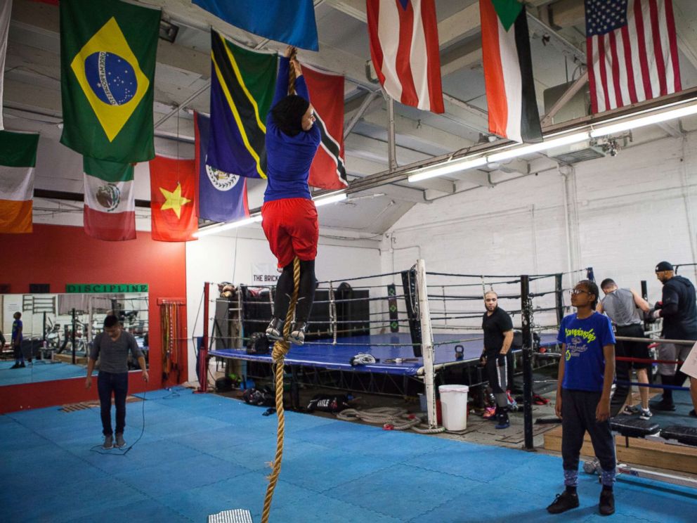 PHOTO: Amaiya Zafar attempts to climb the rope and touch the ceiling at Circle of Discipline boxing gym in Minneapolis.
