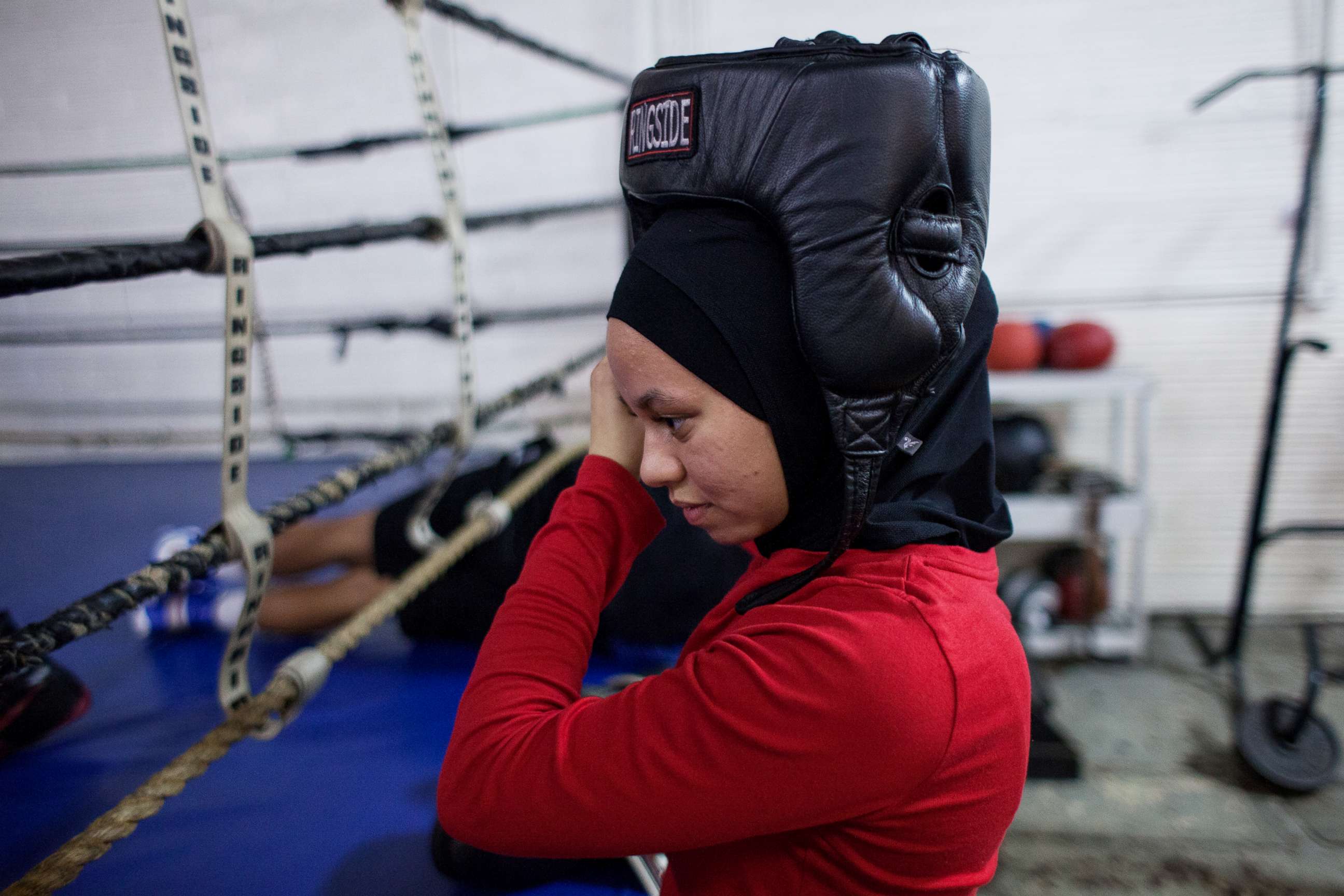 PHOTO: Amaiya wears her hijab under her helmet as she prepares to spar at Circile of Discipline gym.