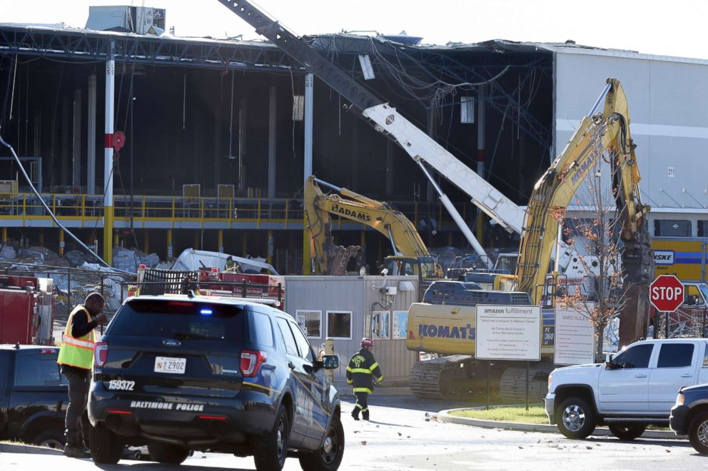 PHOTO: Emergency personnel look over a damaged truck, Nov. 3, 2018, after a weather-related building collapse at an Amazon distribution warehouse in Baltimore.