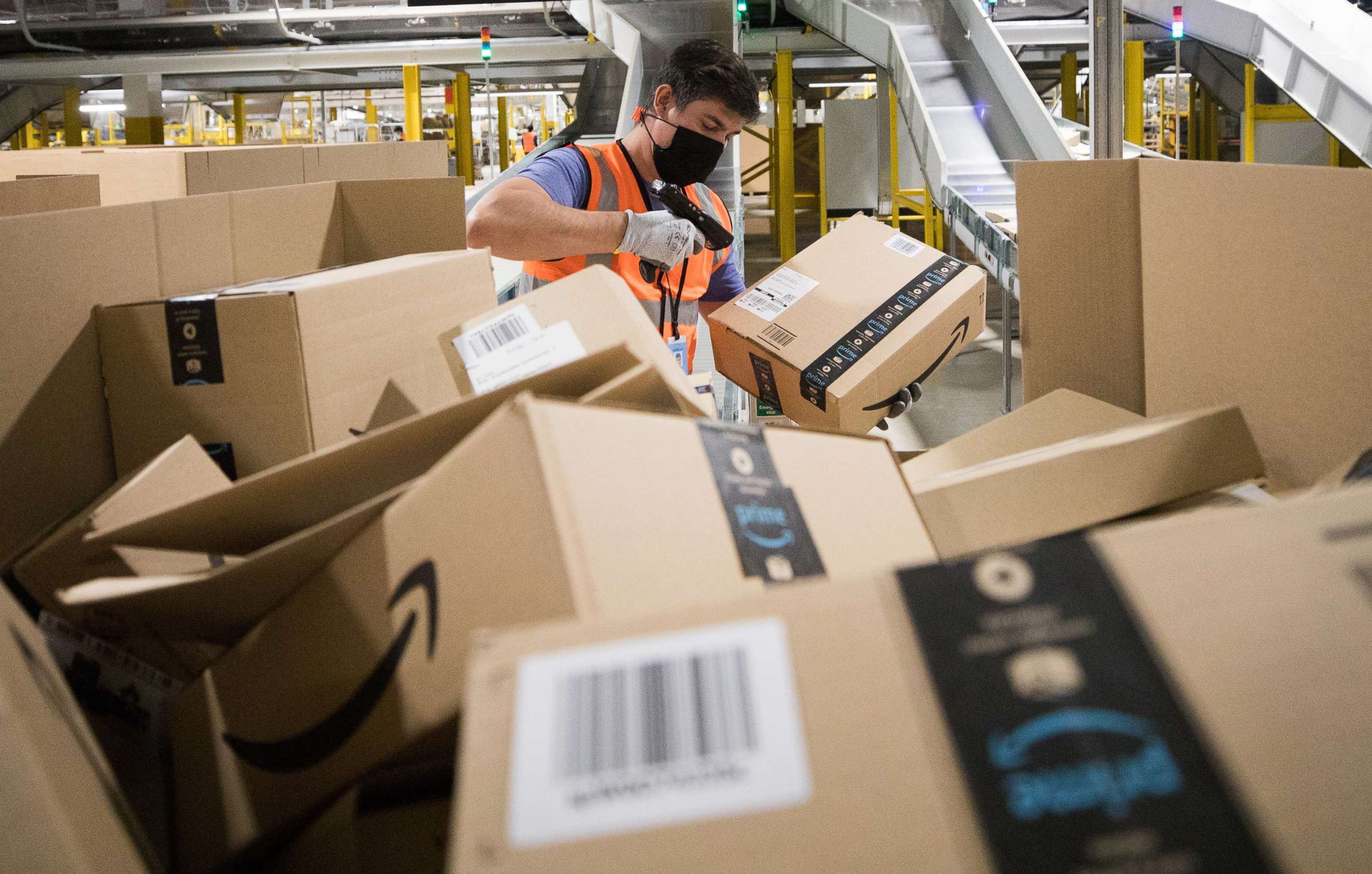 PHOTO: An employee wearing a protective mask scans a package at an Amazon.com Inc. fulfillment center in Kegworth, United Kingdom, Oct. 12, 2020. 