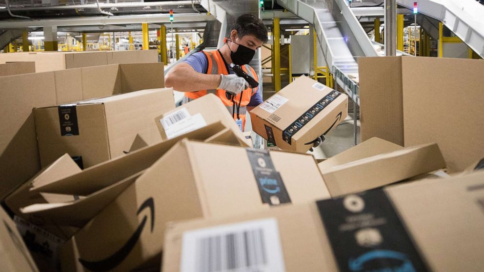 PHOTO: An employee wearing a protective mask scans a package at an Amazon.com Inc. fulfillment center in Kegworth, United Kingdom, Oct. 12, 2020. 