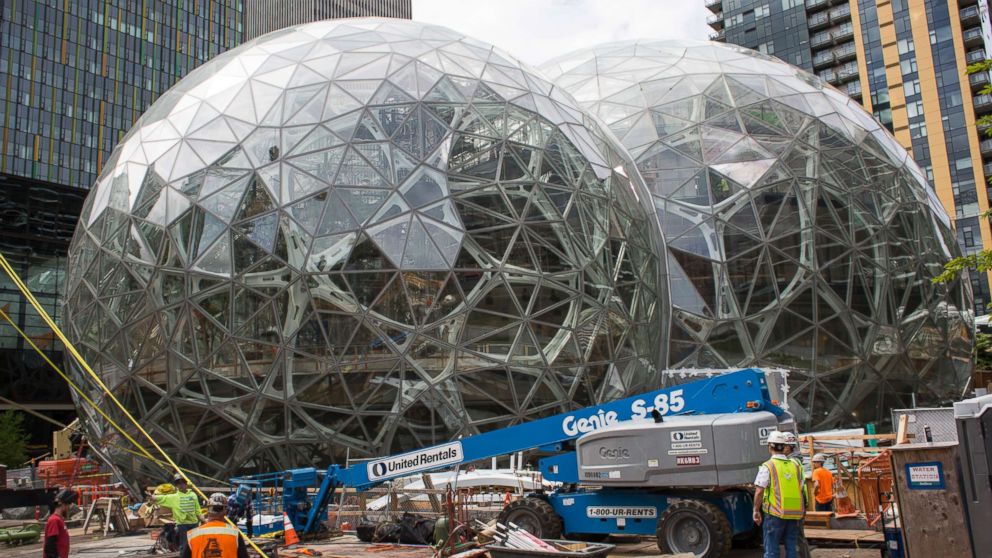 Workers surround the signature glass spheres under construction at the Amazon corporate headquarters, June 16, 2017, in Seattle.