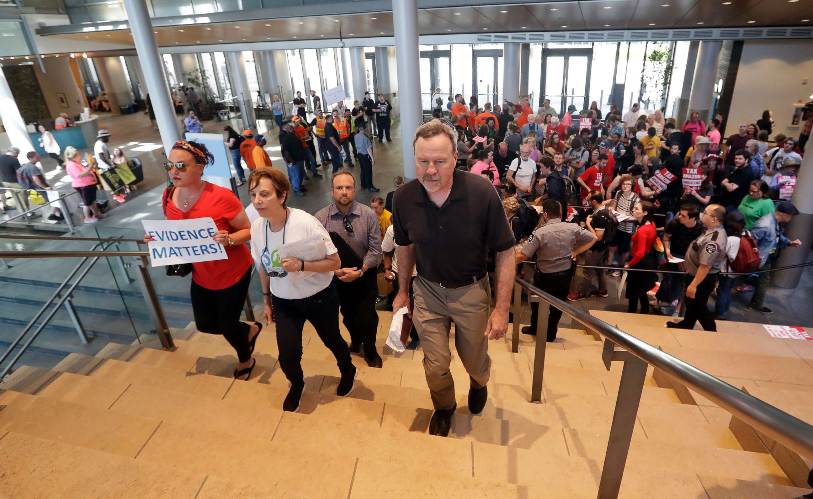 PHOTO: People head in to a Seattle City Council after filling the lobby below before a meeting where the council was expected to vote on a "head tax," May 14, 2018, in Seattle.