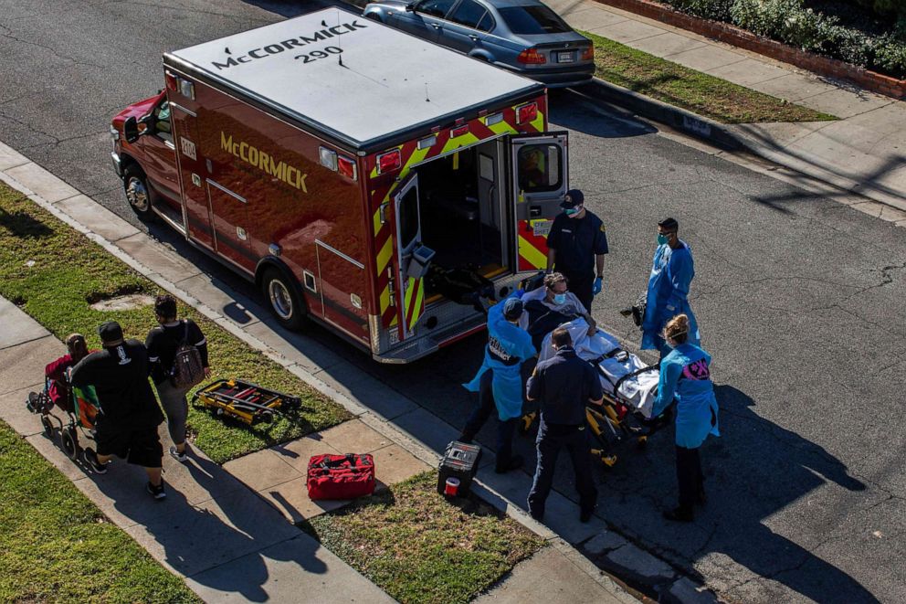 PHOTO: After administering him with oxygen, Los Angeles County paramedics load a potential COVID-19 patient into an ambulance before transporting him to a hospital in Hawthorne, California, on Dec. 29, 2020.