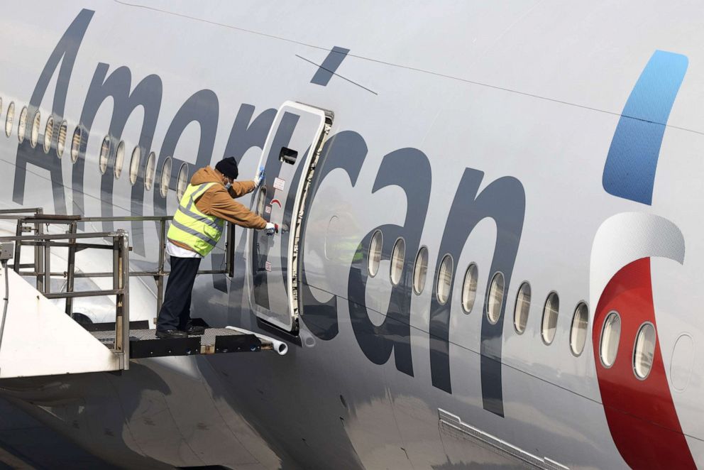 PHOTO: A worker closes the door on an American Airlines plane at a gate at John F. Kennedy International Airport in New York, March 26, 2021.