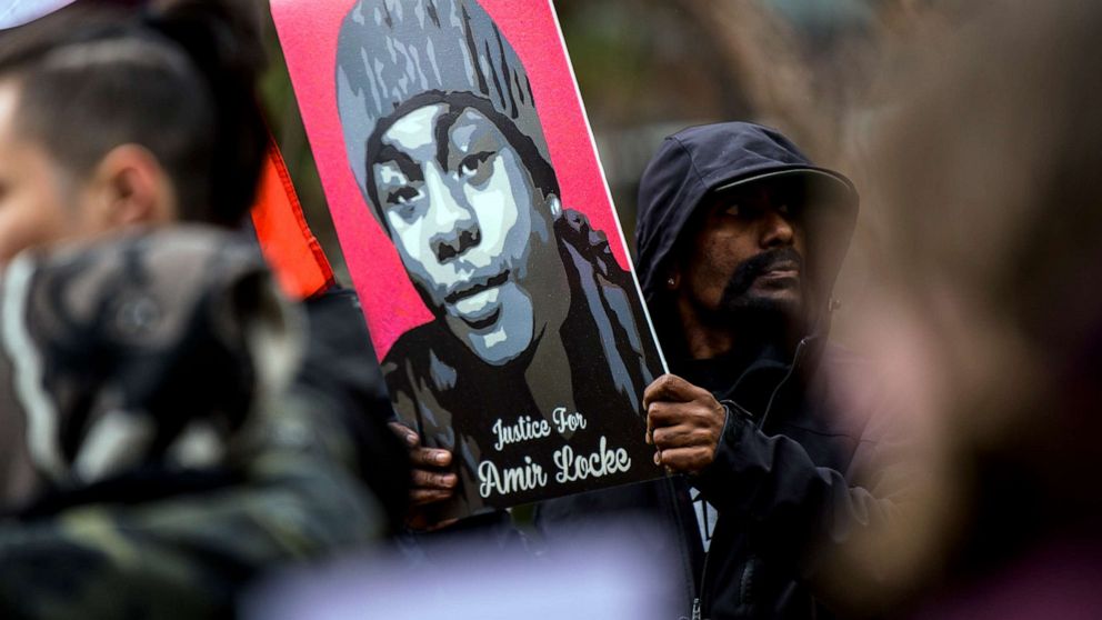 PHOTO: A man holds a portrait of Amir Locke during a news conference outside the Hennepin County Government Center on April 6, 2022, in Minneapolis.