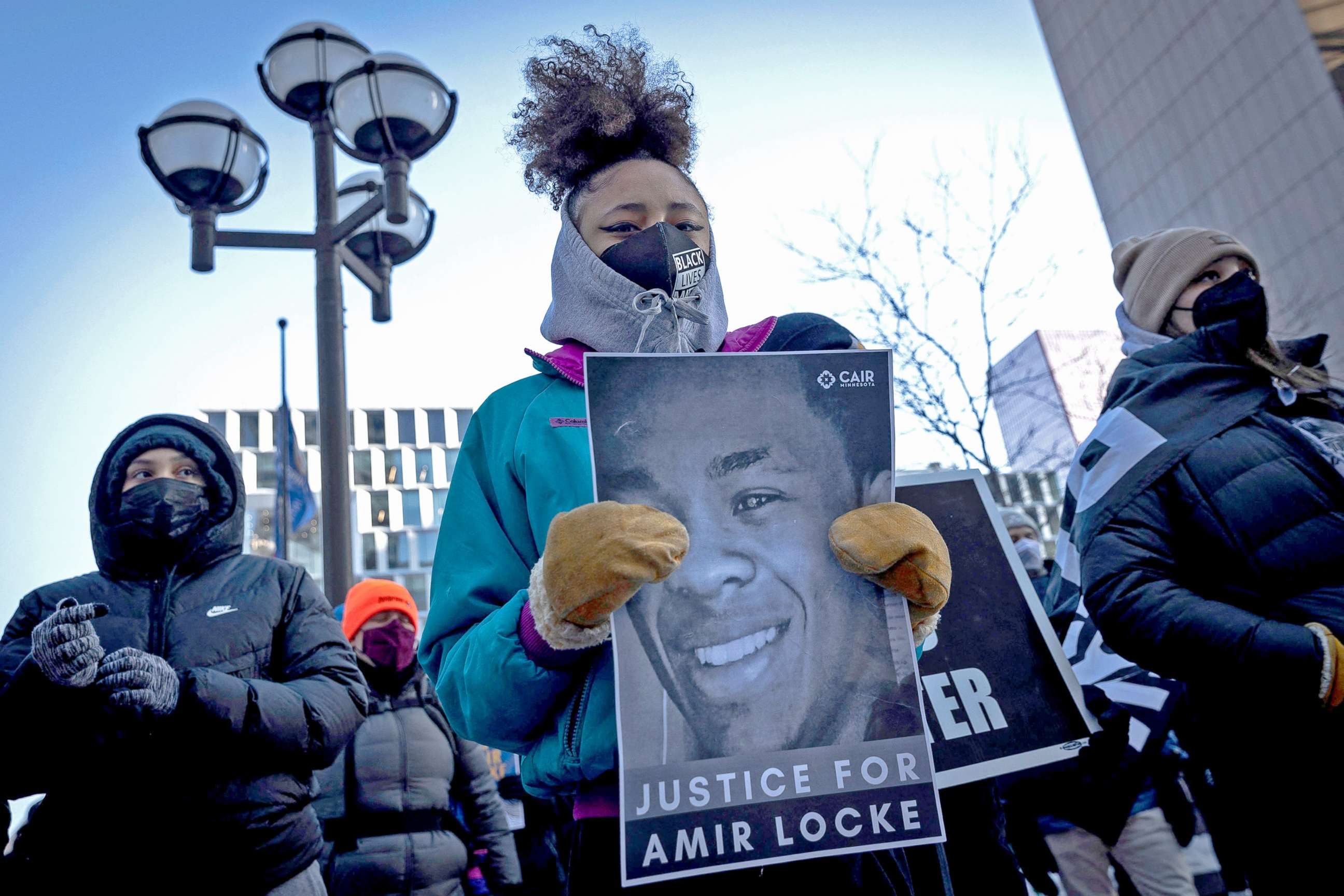 PHOTO: Demonstrators hold placards during a rally in protest of the killing of Amir Locke, outside the Hennepin County Government Center in Minneapolis, Minnesota on February 5, 2022.